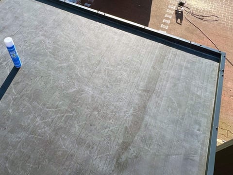 Hochwertige EPDM-Dachfolie auf Flachdach angebracht EPDM-Dachfolie professionell auf einem Flachdach verlegt, im Hintergrund Arbeitsmaterialien und Werkzeuge sichtbar
